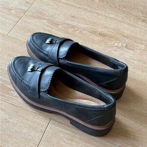 Black leather loafers with metal detailing